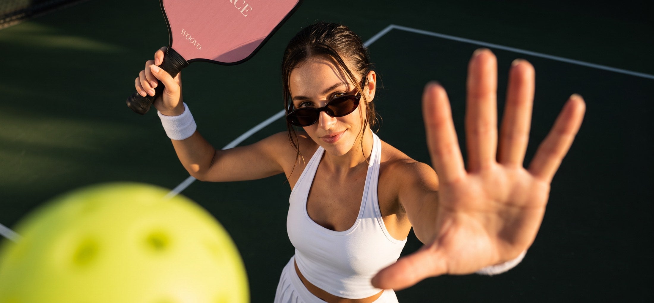 A player holding up a WOOVO paddle on the court